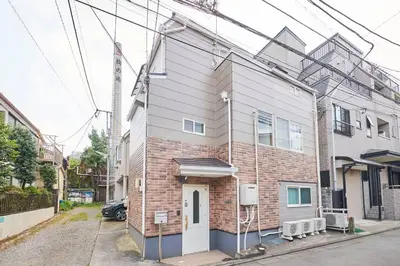 a brick building with a white door on a street at \u4e0a\u843d\u5408\u30cf\u30a6\u30b9 KAMIOCHIAI HOUSE in Tokyo