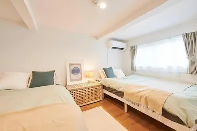 a bedroom with two beds and a window at \u4e0a\u843d\u5408\u30cf\u30a6\u30b9 KAMIOCHIAI HOUSE in Tokyo