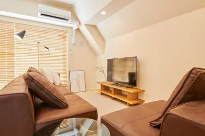 a living room with a couch and a television at \u6c5f\u6238\u5ddd\u6a4b\u30ec\u30b8\u30c7\u30f3\u30b9 EDOGAWABASHI RESIDENCE in Tokyo