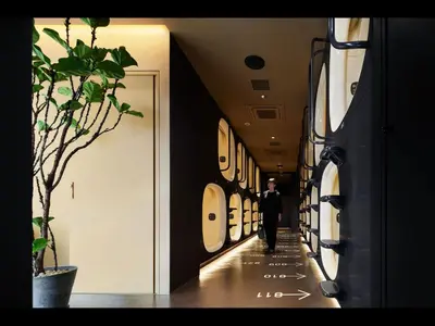 a man walking down a hallway in a building at 9h nine hours woman Shinjuku in Tokyo