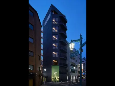 a tall building on a city street at night at 9h nine hours woman Shinjuku in Tokyo