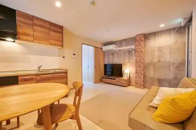 a kitchen and living room with a table and a couch at \u738b\u5b50\u795e\u8c37\u30cf\u30a6\u30b9 OJIKAMIYA HOUSE in Tokyo