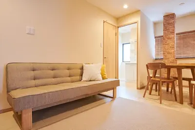 a living room with a couch and a table at \u738b\u5b50\u795e\u8c37\u30cf\u30a6\u30b9 OJIKAMIYA HOUSE in Tokyo