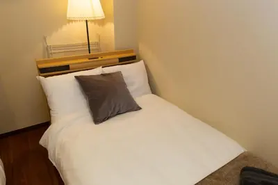 a bedroom with a white bed with a pillow on it at \u5510\u6ca2\u30db\u30c6\u30eb Karasawa-Hotel in Tokyo