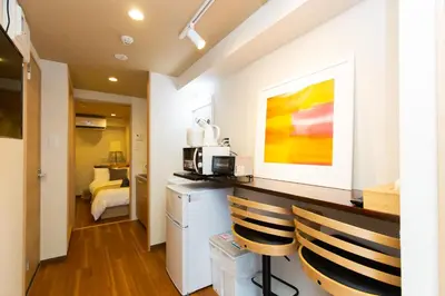 a kitchen with a counter and two chairs in a room at \u5510\u6ca2\u30db\u30c6\u30eb Karasawa-Hotel in Tokyo