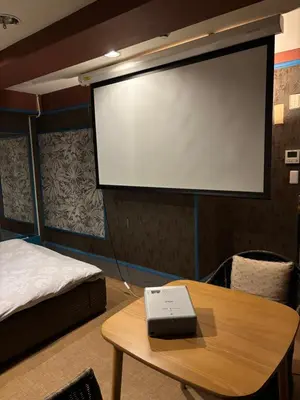 a room with a projector screen and a table at City Hotel Dolphin in Tokyo