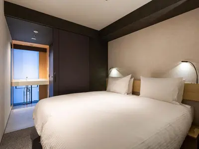 a bedroom with a large white bed and a window at Akabane Holic Hotel in Tokyo