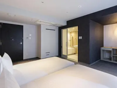 a bedroom with a white bed and a bathroom at Akabane Holic Hotel in Tokyo