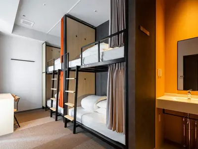 two bunk beds in a room with a sink at Akabane Holic Hotel in Tokyo