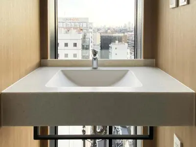 a white sink in front of a window at Akabane Holic Hotel in Tokyo