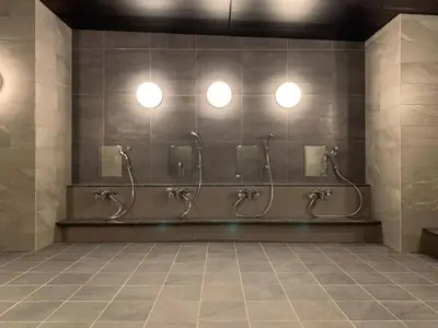 a bathroom with three stalls with sinks and mirrors at Akabane Holic Hotel in Tokyo