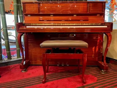 a wooden piano with a stool in front of it at Centurion Hotel Ueno in Tokyo