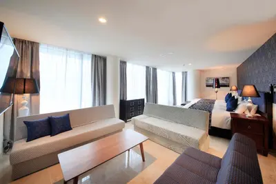 a living room with a couch and a bed at Centurion Hotel Ueno in Tokyo