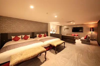 a bedroom with two beds and a living room at Centurion Hotel Ueno in Tokyo