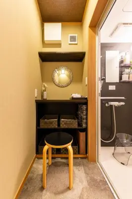 a small stool in a bathroom with a mirror at YADOYA Yumeji in Tokyo
