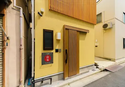 a yellow building with a door on the side of it at YADOYA Iroha in Tokyo