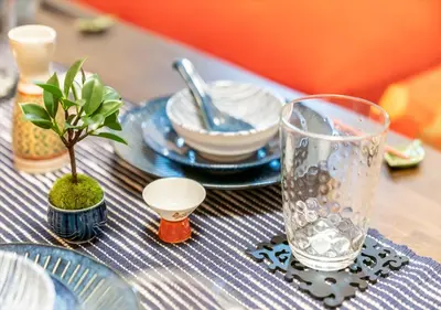 a table with a blue and white table cloth with a glass at YADOYA Yanagitori East in Tokyo