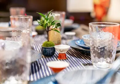 a table with glasses and a potted plant on it at YADOYA Yanagitori East in Tokyo
