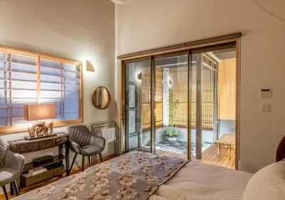 a bedroom with a bed and a desk and a window at YADOYA Yanagitori West in Tokyo