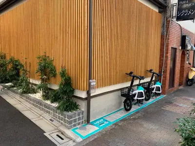 two scooters parked on a sidewalk next to a building at YADOYA Yanagitori West in Tokyo