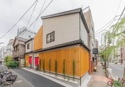 an orange and white building on the side of a street at YADOYA Yanagitori West in Tokyo