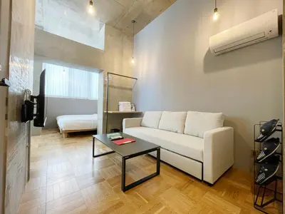 a living room with a white couch and a table at PRISM INN OGU in Tokyo