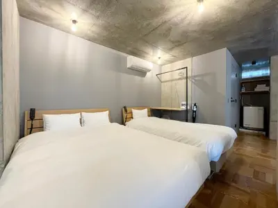 two beds sitting next to each other in a room at PRISM INN OGU in Tokyo