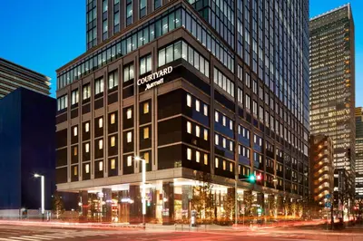 a tall building with a sign on the side of it at Courtyard by Marriott Tokyo Station in Tokyo