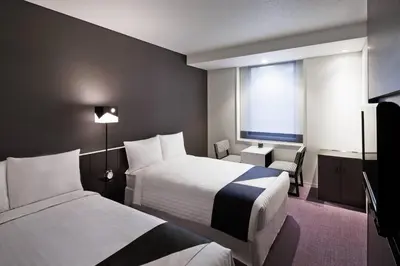 a hotel room with two beds and a window at Courtyard by Marriott Tokyo Station in Tokyo