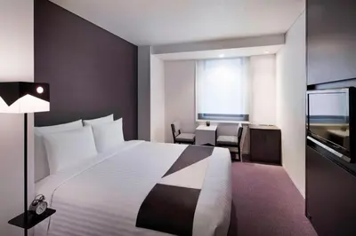 a hotel room with a large bed and a desk at Courtyard by Marriott Tokyo Station in Tokyo