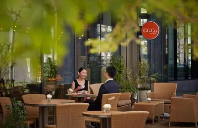 a man and woman sitting at tables in a restaurant at Courtyard by Marriott Tokyo Station in Tokyo