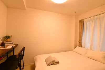 a small room with a bed and a desk and a window at FL Residence Todai II in Tokyo
