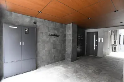 a room with a stone wall and two elevators at FL Residence Todai II in Tokyo