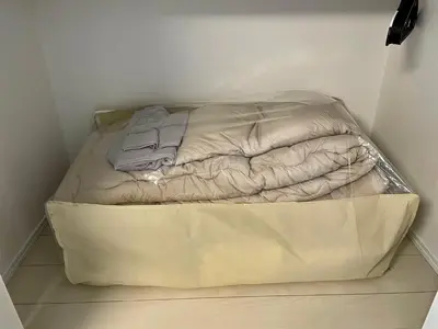 a small bed in a corner of a room at FL Residence Todai II in Tokyo