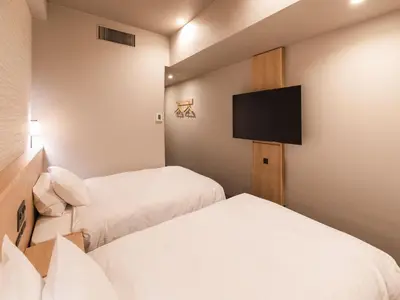 a hotel room with two beds and a flat screen tv at SOTETSU GRAND FRESA TAKADANOBABA in Tokyo