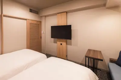 a hotel room with two beds and a flat screen tv at SOTETSU GRAND FRESA TAKADANOBABA in Tokyo