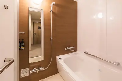 a bathroom with a tub and a sink and a mirror at SOTETSU GRAND FRESA TAKADANOBABA in Tokyo