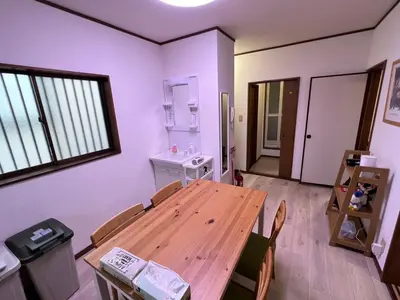 a dining room with a wooden table and chairs at Sepia Court Inn \u30bb\u30d4\u30a2\u30b3\u30fc\u30c8\u30a4\u30f3 in Urayasu