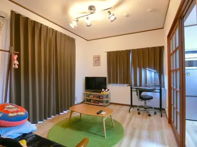 a living room with a table and a television and a desk at Sepia Court Inn \u30bb\u30d4\u30a2\u30b3\u30fc\u30c8\u30a4\u30f3 in Urayasu