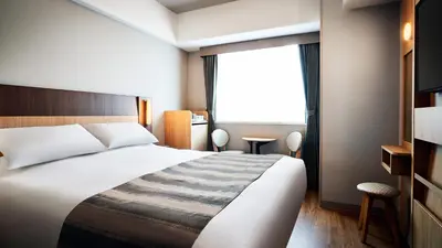 a hotel room with a bed and a window at Hotel Monte Hermana Tokyo in Tokyo