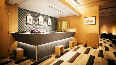 a lobby with a waiting room with a counter and flowers at Hotel Monte Hermana Tokyo in Tokyo