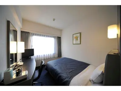 a hotel room with a bed and a desk and a window at Grand Central Hotel - Vacation STAY 19600v in Tokyo