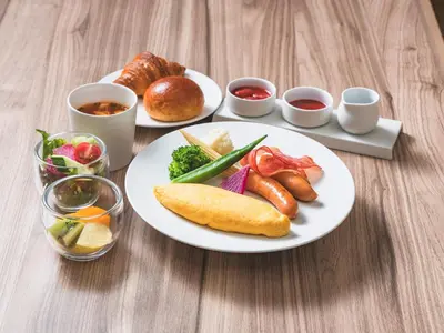 a table with two plates of food and bread at Hotel Rilassare Tokyo in Tokyo