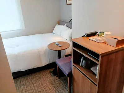 a hotel room with a bed and a small table at Hotel Rilassare Tokyo in Tokyo