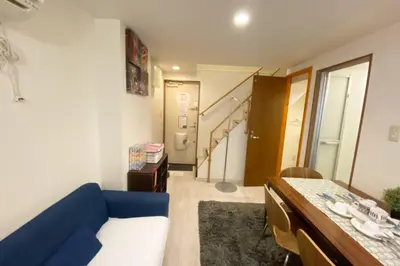 a living room with a blue couch and a staircase at Takemura Building 105 in Tokyo