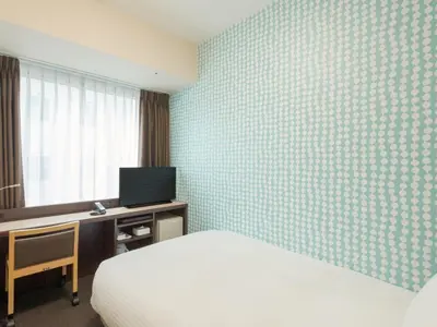 a bedroom with a bed and a desk and a television at Rose Stay Tokyo Shiba Park in Tokyo