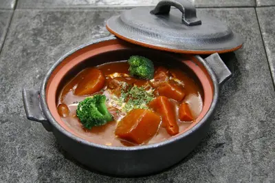 a pot of stew with broccoli and carrots in it at HOTEL555 \u9326\u7cf8\u753a in Tokyo