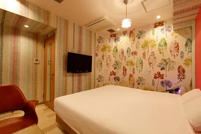 a bedroom with a bed and a tv on the wall at HOTEL555 \u9326\u7cf8\u753a in Tokyo