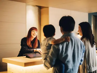 a woman standing at a desk with four children at MIMARU Tokyo Station East in Tokyo