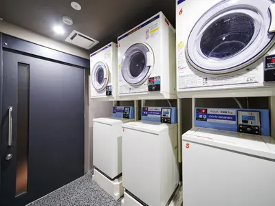 a laundry room with three washing machines and a washer and dryer at MIMARU Tokyo Station East in Tokyo